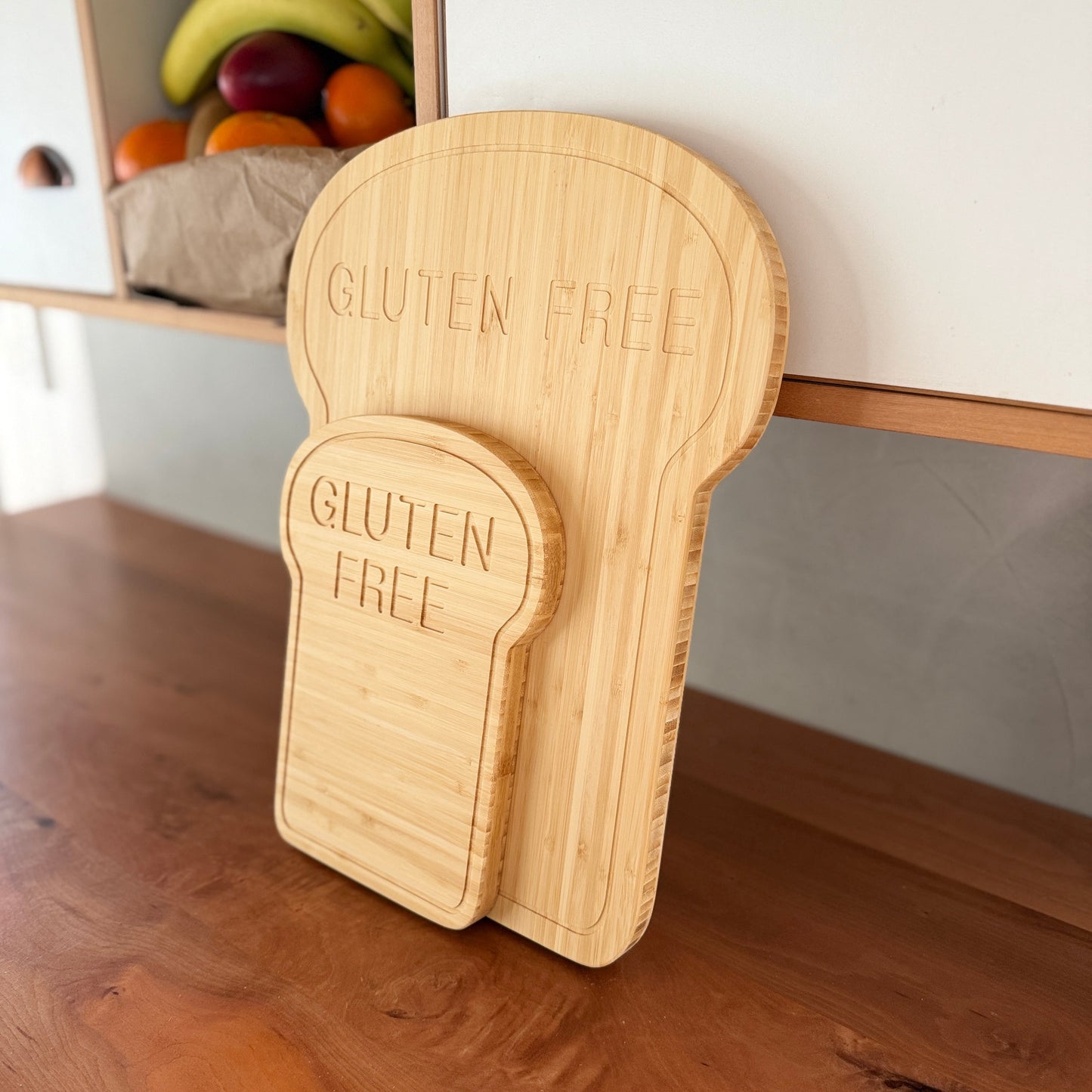 Wooden cutting board shaped like a slice of bread with 'GLUTEN FREE' engraving on a wooden surface.