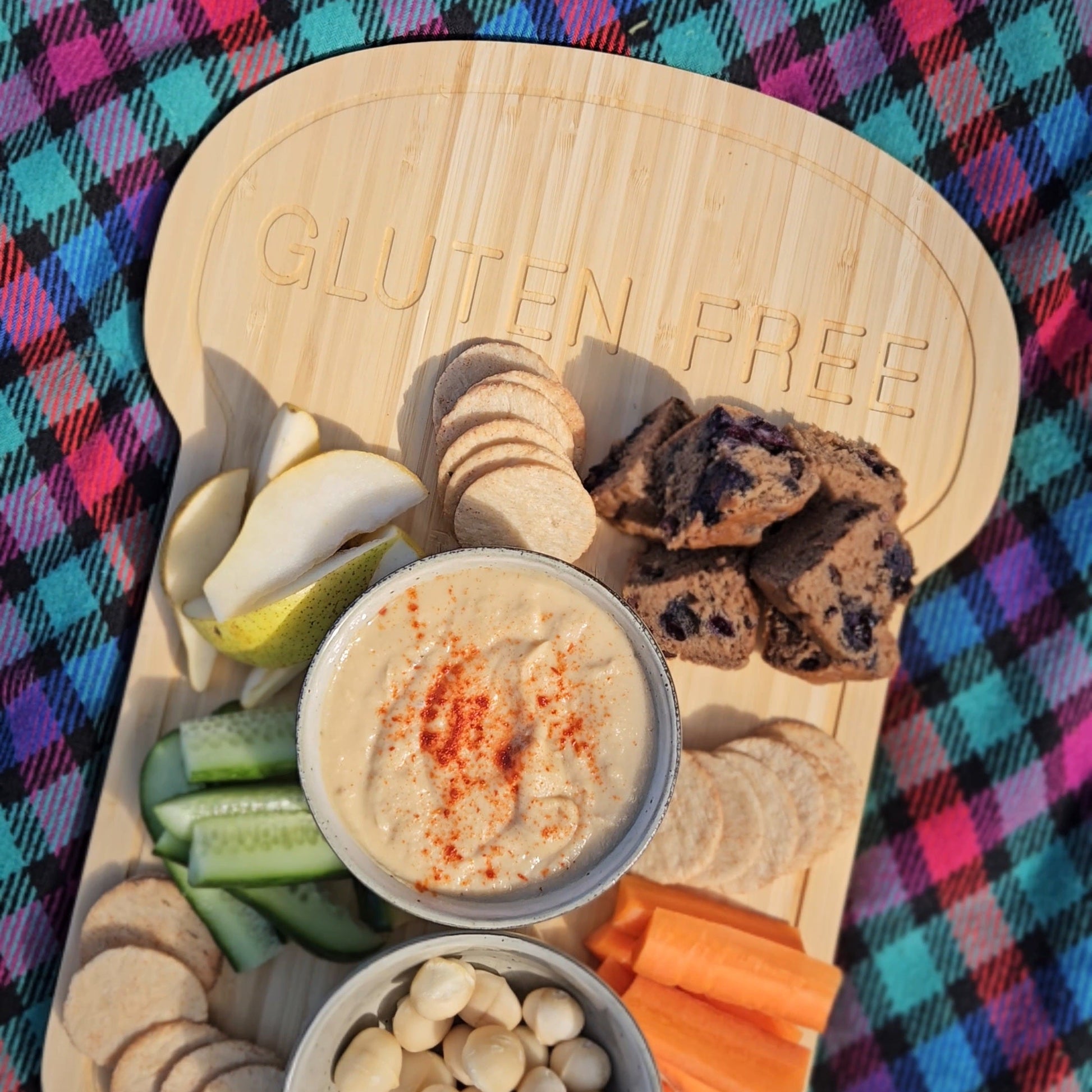 Gluten Free Wooden platter with snacks on a colorful checkered tablecloth